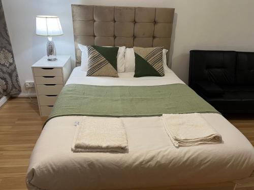 sypialnia z dużym łóżkiem z dwoma ręcznikami w obiekcie Ensuite With Kitchen Ext Large Room With Balcony in Zone 2 w Londynie