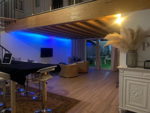 un salon avec une table et un éclairage bleu dans l'établissement La Villa d ´Emma, à Juvignac