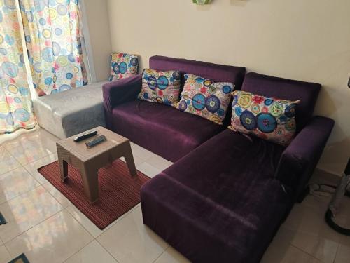 a living room with a purple couch and a table at chalet 9 porto golf marina Egyptian only in El Alamein