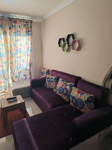 a living room with a purple couch and a table at chalet 9 porto golf marina Egyptian only in El Alamein