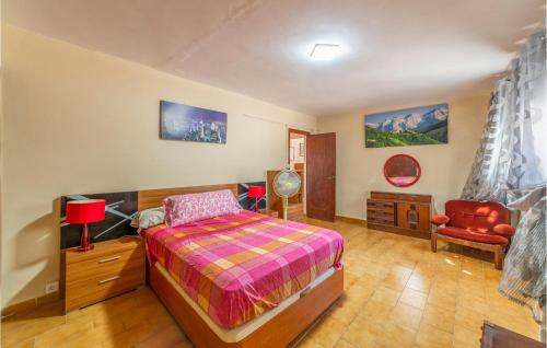 Gorgeous Home In Reus With Kitchenette في ريوس: غرفة نوم بسرير وكرسي