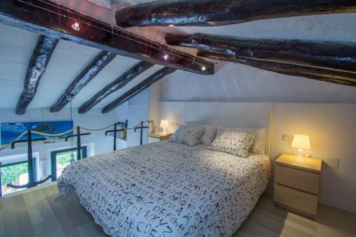 1 dormitorio con cama blanca en una habitación con vigas en Fisherman's house, 1st line of sea en Tarragona