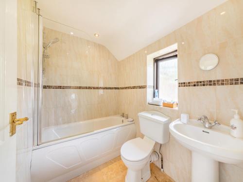 a bathroom with a tub and a toilet and a sink at Pennine View in Long Marton