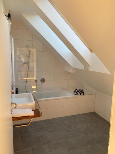 La salle de bains est pourvue d'un lavabo et d'une baignoire. dans l'établissement Salzburg-Loft im Stadtteil Leopoldskron-Moos 120qm mit Balkon & Untersbergblick, à Salzbourg