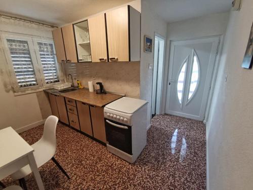a small kitchen with a sink and a stove at Guesthouse Eljuga Family in Stari Grad