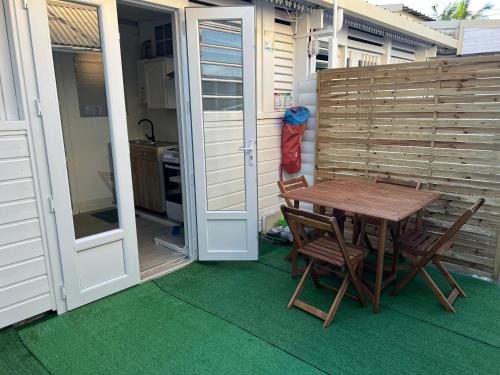 a wooden table and chairs on a patio with a door at EVASION CONVIVIALE in Le Tampon