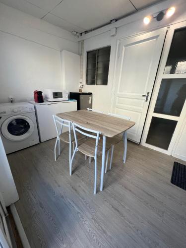 a kitchen with a table and a washing machine at EVASION CONVIVIALE in Le Tampon