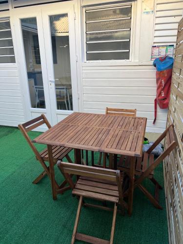 a wooden picnic table and two chairs on a porch at EVASION CONVIVIALE in Le Tampon