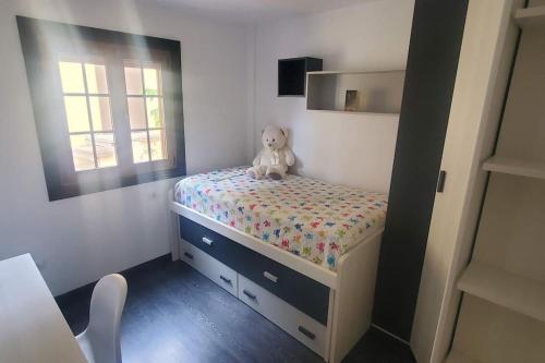- une petite chambre avec un ours en peluche assis sur un lit dans l'établissement Stylish apartment in Tegueste, à Tegueste