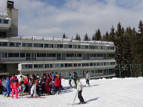 a group of people standing in the snow in front of a building at Appartamento Artuik in Marilleva