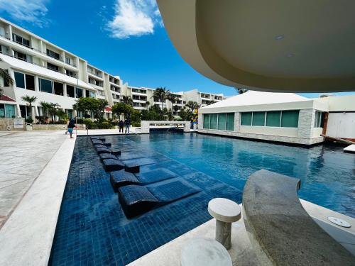 uma piscina com espreguiçadeiras ao lado de um edifício em Solymar Beach Condos em Cancún