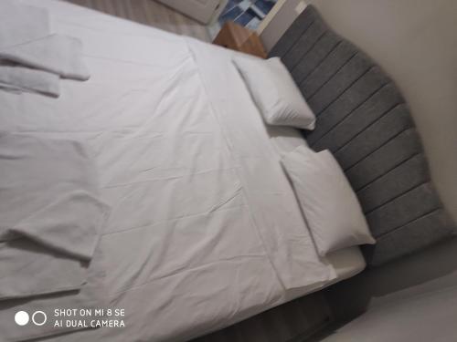 łóżko z białą pościelą i poduszkami w obiekcie Palmas Apart w Stambule