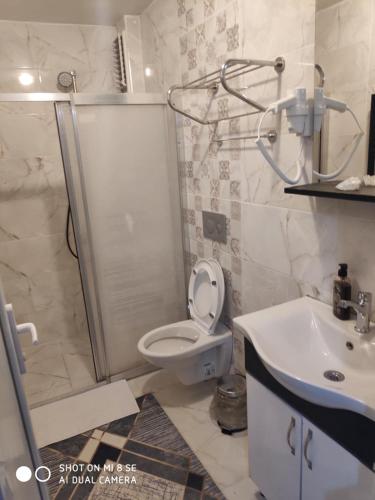 a bathroom with a shower and a toilet and a sink at Palmas Apart in Istanbul