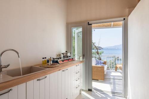 a kitchen with a sink and a view of the ocean at Casa del Mar Milos in Areti