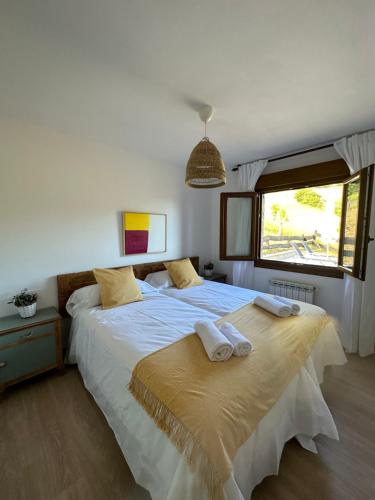 a bedroom with a large bed with towels on it at AIRE DE PICOS Sur in Brez