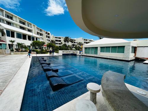 una piscina con sedie a sdraio accanto a un edificio di The Suites of Solymar a Cancún