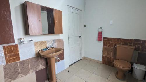 y baño con lavabo y aseo. en La casita, en Cochabamba