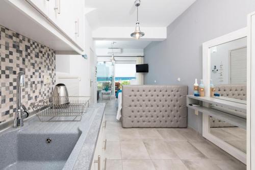 a bathroom with a large sink and a tub at Artemis Beach Apartments in Chrysi Ammoudia