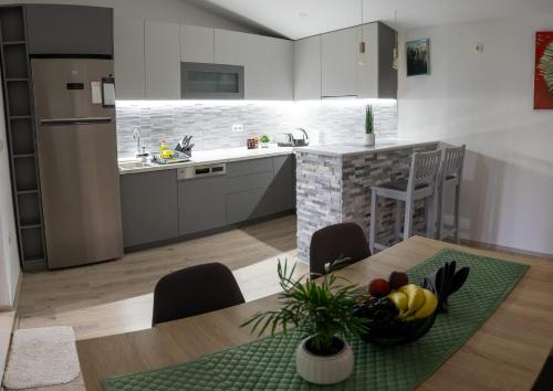 eine Küche mit einem Tisch und einer Obstschale darauf in der Unterkunft AP apartment in Mostar