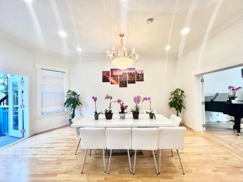 New Modern Spacious 4bdr Home by Golden Gate Park في سان فرانسيسكو: غرفة طعام مع طاولة بيضاء وكراسي بيضاء
