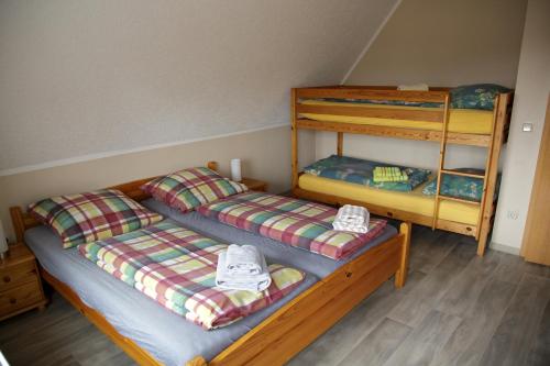 two twin beds in a room with a bunk bed at Gästehaus am Kirschberg in Ilsenburg