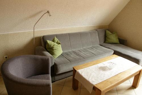 a living room with a couch and a chair and a table at Gästehaus am Kirschberg in Ilsenburg