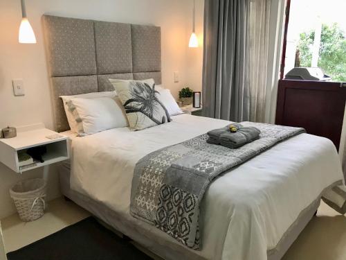 a bedroom with a large bed and a window at Aloe Croft in Howick