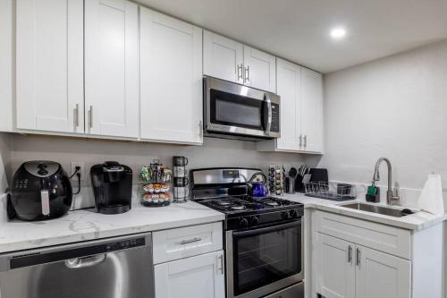 uma cozinha branca com um fogão e um micro-ondas em San Diego's Cozy Gem em San Diego