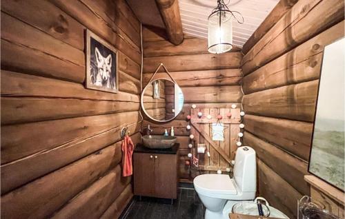 a bathroom with wooden walls and a toilet and a sink at 4 Bedroom Amazing Home In Nord-torpa in Nord Torpa