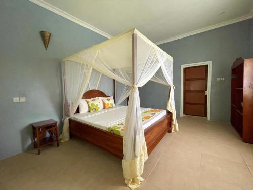 a bedroom with a bed with a canopy at Green's Nungwi in Nungwi