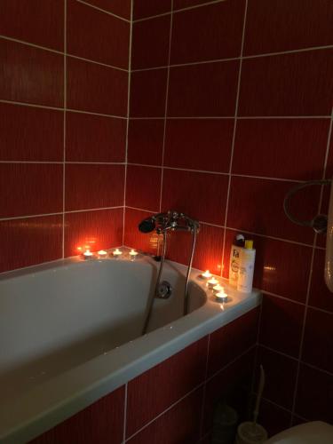 a bathroom with a bath tub with candles in it at Kuca za odmor DIVA in Mostar