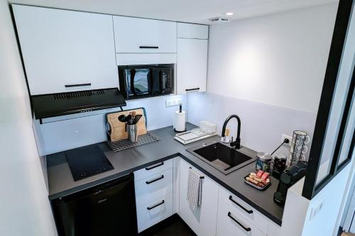 a small kitchen with a sink and a microwave at Studio indépendant, calme, avec parking privé et grand jardin, proche de Toulouse in Villeneuve-Tolosane