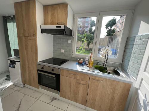 uma pequena cozinha com um lavatório e uma janela em Cosy home with babyfoot near Paris & Disney em Noisy-le-Sec