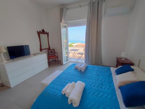 Un dormitorio con una cama azul con toallas. en GiErre Apartment, en Termini Imerese