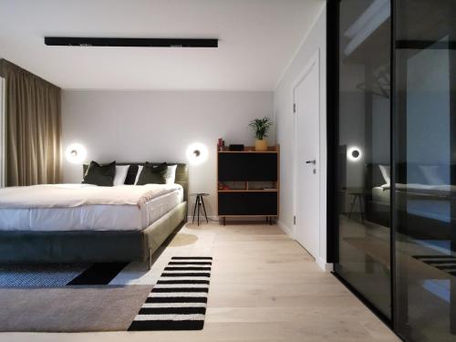 a bedroom with a bed and a glass door at Albatross RELAX seaside design apartment with terrace in Ķesterciems