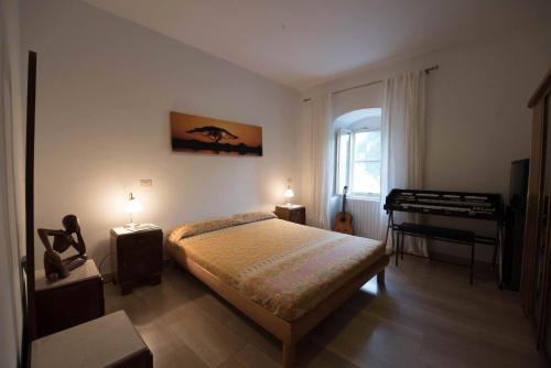 - une chambre avec un lit et un piano dans l'établissement Azienda Agricola Villa Castelluccia, à Foce Varano