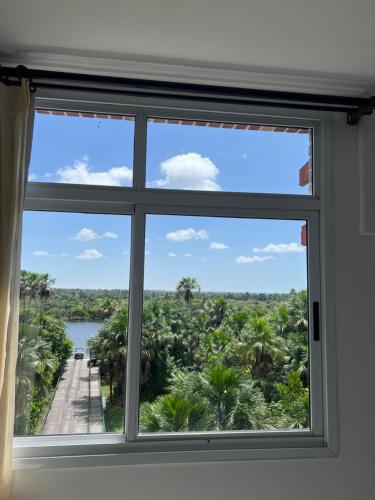 a window with a view of a river and palm trees at Flat Gran Lençóis in Barreirinhas