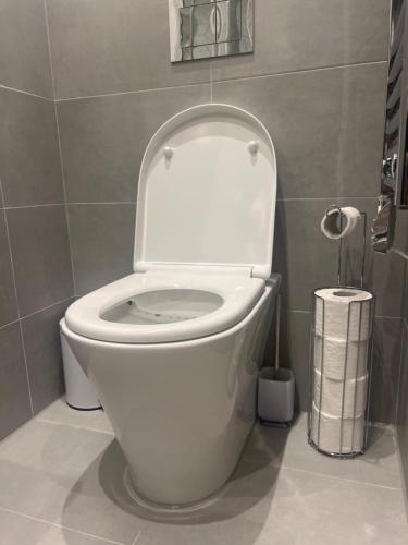 a bathroom with a toilet with the lid up at London Heathrow Airport Apartment Voyager House Terminal 12345 - EV electric and Parking available in New Bedfont