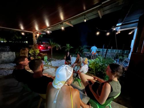 un gruppo di persone seduti sotto una tenda di notte di ALAROOTS HUAHINE a Haapu