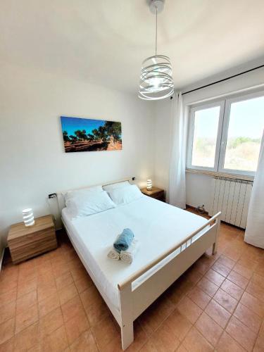 ein Schlafzimmer mit einem großen weißen Bett in einem Zimmer in der Unterkunft Villetta Privata in Salento a 15minuti da Gallipoli in Casarano