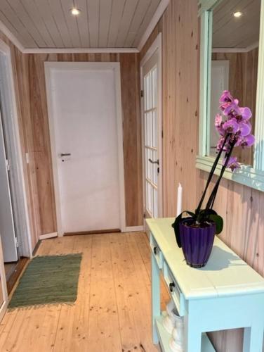 ein Zimmer mit einem Tisch mit einer Blumenvase darauf in der Unterkunft Green Garden in Sørvágur