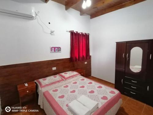 1 dormitorio con cama, tocador y espejo en La Mulata Apart en Puerto Iguazú