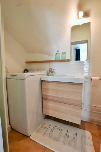 a bathroom with a sink and a toilet and a mirror at Appartement au coeur de la ville de Taverny in Taverny