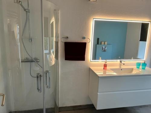 a bathroom with a sink and a shower with a mirror at Green Garden in Sørvágur