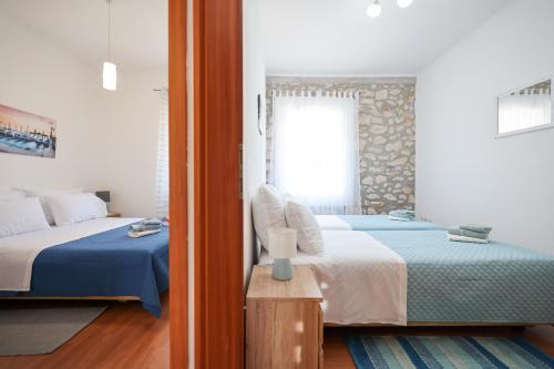1 dormitorio con 2 camas y ventana en Apartment M&V, en Zadar