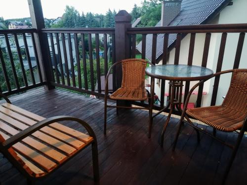 uma varanda com 2 cadeiras e uma mesa e uma mesa e cadeiras em Apartament Charzykowy em Charzykowy