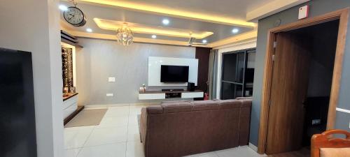 ein Wohnzimmer mit einem Sofa und einem TV in der Unterkunft Premium private room & attached washroom in a flat in Bangalore