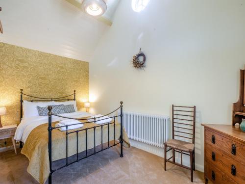 a bedroom with a bed and a wooden dresser at The Old Reading Room in Salhouse