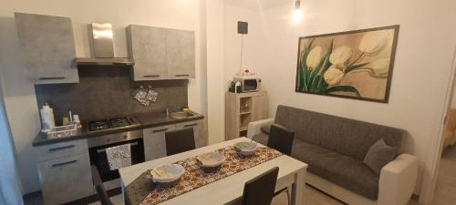 een keuken en een woonkamer met een tafel en een bank bij Appartamento Montibò in Villanova dʼAsti