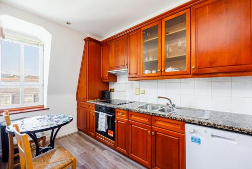 a kitchen with wooden cabinets and a table at CARLTON COURT - MAYFAIR in London